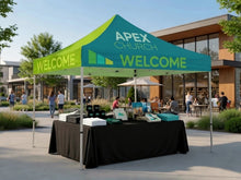 Load image into Gallery viewer, Custom-printed 10x10 church event tent set up as a welcome station
